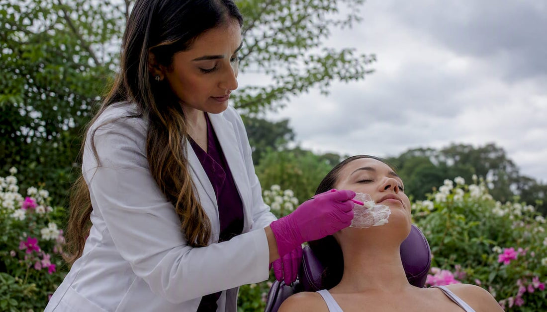 Dermatologist applying numbing cream on patient cheek