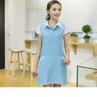 Nail salon professional wearing a stylish blue dress with pockets, showcasing beauty aesthetics in a polished and professional setting.