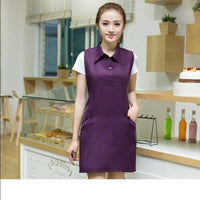 Woman wearing a purple nail salon dress with pockets, showcasing stylish and functional beauty aesthetics in a professional setting.
