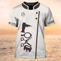 Stylish salon tee with hairdressing tools print, ideal for beauty aesthetics professionals on a scenic beach background.